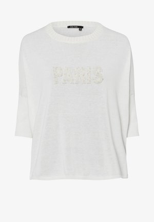 White loose-fit sweater with short sleeves and ribbed neckline, featuring "PARIS" in textured, pearl-like accents. Soft, lightweight material.