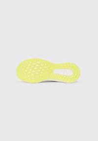 Semelle de chaussure en jaune vif, avec un motif de crampons texturé et plusieurs trous de drainage pour une traction et une flexibilité optimales.