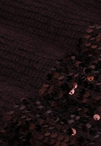 Tiefburgunderfarbenes Strickgewebe mit einer weichen Textur, verziert mit glänzenden, runden Pailletten in verschiedenen Schattierungen von Burgunder, die einen geschichteten Effekt erzeugen.