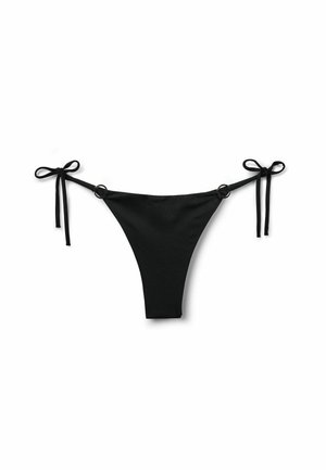 Schwarzer Bikini-Slip mit seitlichen Bändern und Metallringen vor weißem Hintergrund.