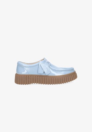 Light blue patent leather loafer with thick brown ribbed sole and matching laces, shown from the side on a white background.