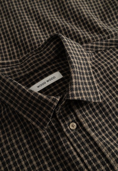 Galléros ing fekete és barna kockás mintával, puha anyagból, "WOOD WOOD" felirattal és egyetlen bézs gomb részlettel.
