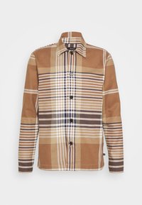 Camisa a cuadros marrón hecha de tela con cuello, mangas largas y cierre de botón en la parte frontal. Presenta líneas blancas, beige y azul marino en el patrón.