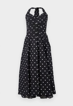 Schwarzes Halterkleid mit weißen Polka-Dots, taillierte Bluse, Schnürdetails und einem ausgestellten Rock. Hergestellt aus glattem Material mit leichtem Glanz.