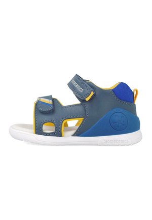 Sandalini blu e gialli con tomaia in materiale sintetico, cinturini in Velcro, ritagli per traspirabilità e suola in gomma bianca. Logo del marchio sul lato.