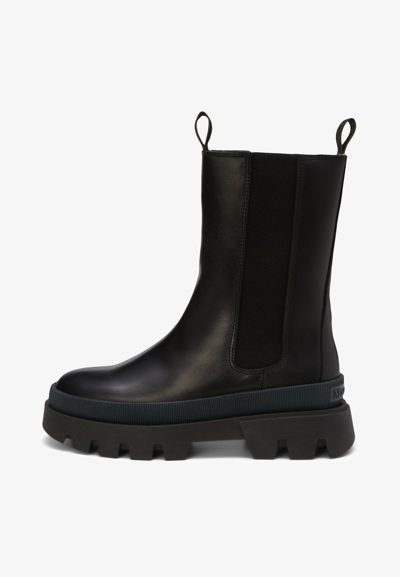 Botte mi-mollet en cuir noir avec semelle épaisse à crampons, panneaux latéraux élastiques et languettes à tirer à l'avant et à l'arrière pour un enfilage facile.