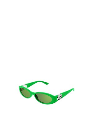 Occhiali da sole in plastica verde con forma ovale, lenti verde scuro e dettagli metallici sulle aste con un design decorativo.