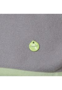 Stickad tröja i grått med en ljusgrön nederkant. Har en liten rund grön tagg med "StreetOne"-logotypen fäst. Slät textur.