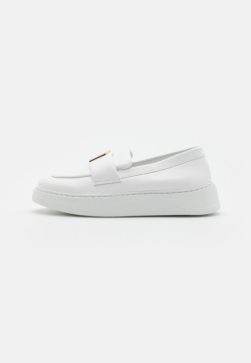 Scarpa slip-on in pelle bianca con una finitura liscia, suola rialzata, cuciture sottili e un accento dorato sulla tomaia.
