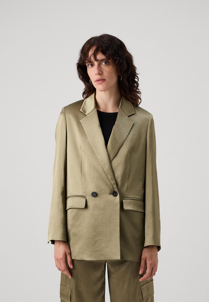 Blazer doppiopetto verde oliva in un tessuto texturizzato, con bottoni neri, rever a punta e tasche a filetto.