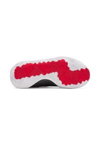 Semelle de chaussure de sport noire avec une surface texturée blanche et des accents en caoutchouc rouge. Présente un motif de semelle ondulée pour une traction optimale.
