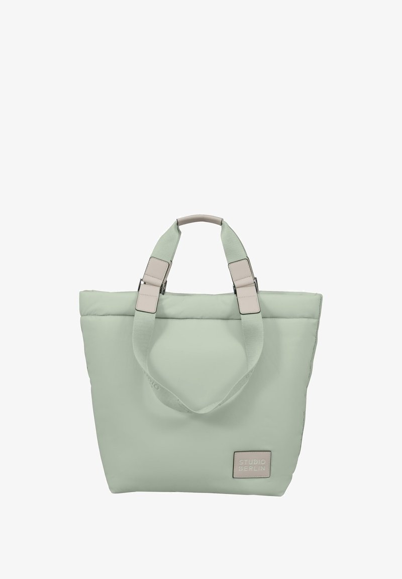 Light green tote bag with a soft texture, padded design, dual top handles, and a rectangular shape. Features a beige logo patch.