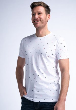 Kortærmet hvid t-shirt med et mønster af små marineblå og røde trekanter. Lavet af blødt stof med en klassisk rund hals.