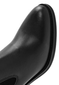 Stivaletto in pelle nera con finitura liscia, punta rotonda, pannelli elastici laterali e suola in gomma nera robusta.