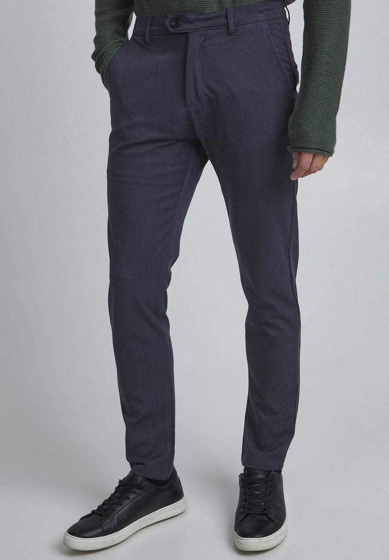 Grå skräddarsydda byxor i strukturerat tyg, med flat front, sidfickor och slim fit, kombinerat med svarta sneakers.