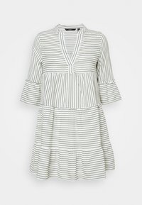 Valkoinen mekko, jossa on viistot vihreät raidat, V-pääntie ja kolmanneksen pituiset kellohihat. Mekossa on kerroksellinen muotoilu ja röyhelöhelma.