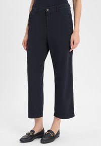 Marineblauwe broek met een rechte snit, voorzien van een knoopsluiting, zijzakken en een opgerolde zoom aan de onderkant. Gemaakt van lichtgewicht stof.