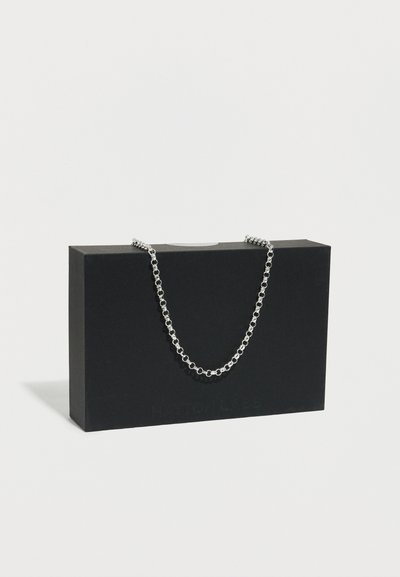 Collier en argent présenté sur une boîte rectangulaire noire. La chaîne est composée de maillons circulaires avec une finition lisse et un design minimaliste.