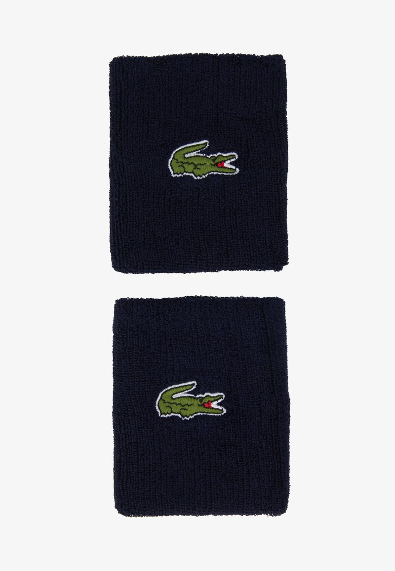 Pulseiras de pulso em tecido terry azul-marinho, com um logótipo de crocodilo verde bordado e detalhes em vermelho. Textura suave com formato retangular.