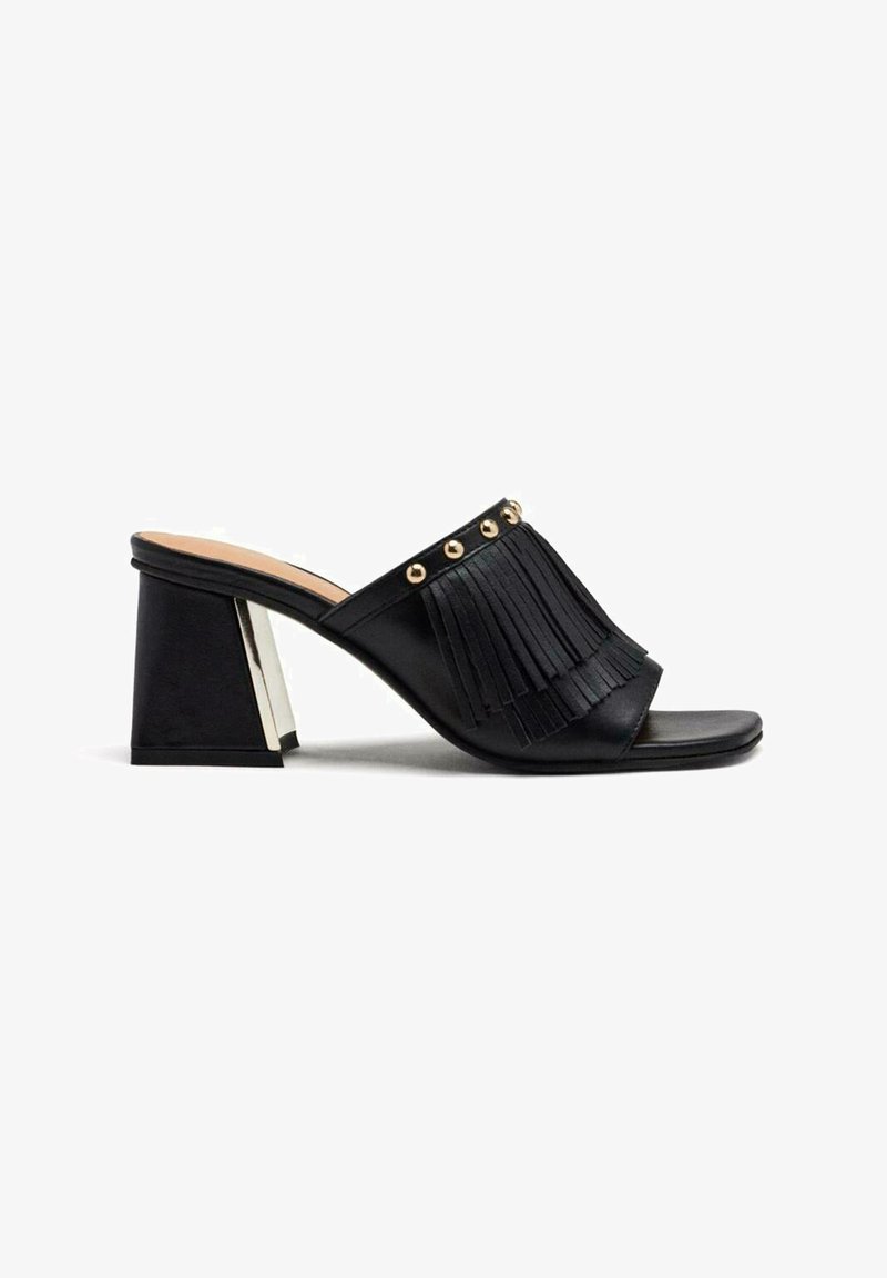 Mules noirs avec des franges et des clous dorés. Bout carré et un talon bloc moyen avec un accent métallisé à l'arrière. Fini en cuir lisse.