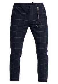 Námořnické kostkované teplákové kalhoty z texturované látky, s elastickým pasem, stahovací šňůrkou a stříbrným řetízkem s kroužkem.