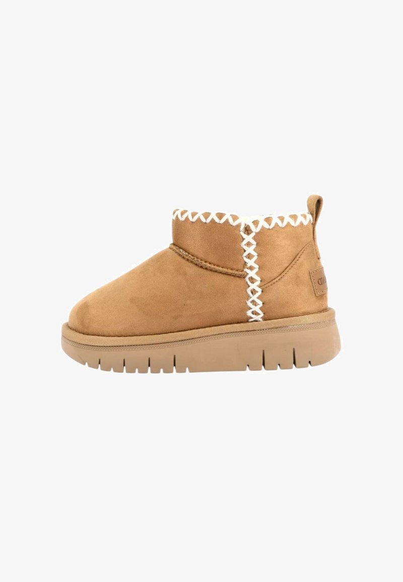 Stivale alla caviglia in suede beige con suola spessa, cuciture incrociate bianche sul bordo superiore e sul lato, e linguetta sul retro.