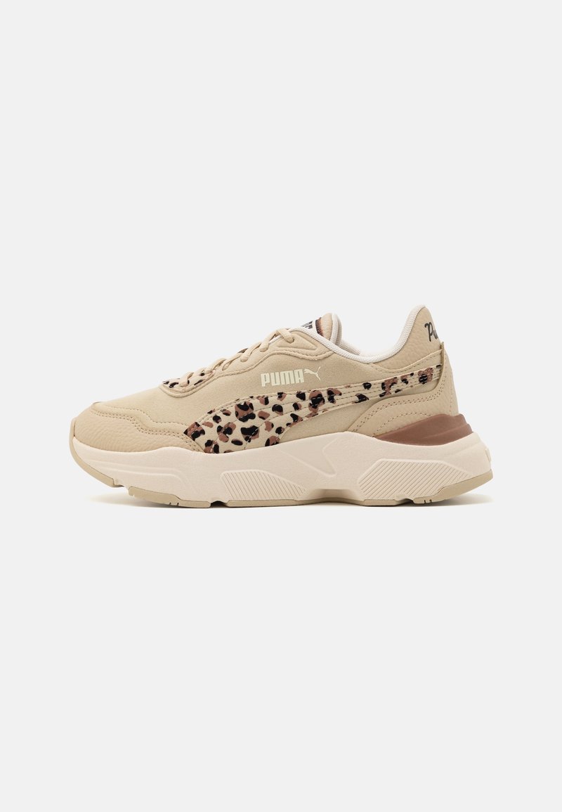 Beżowe sneakersy Puma z boku w cętkowanym wzorze, masywną białą podeszwą i sznurowanym zapięciem, pokazane od zewnętrznej strony na białym tle.