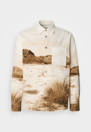 Camisa abotonada de tela de algodón, con un estampado de paisaje en tonos sepia, un bolsillo en el pecho y botones plateados en el frente.