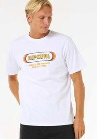 White cotton t-shirt with round neckline featuring a multicolored "RIPCURL" logo and "QUALITY SURF PRODUCTS SINCE SIXTY NINE" text.
