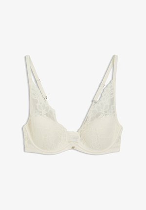 Hvid blonder undertrøje med bøjle, justerbare stropper og blomsterdekor på skåle, vist på en ensfarvet hvid baggrund.