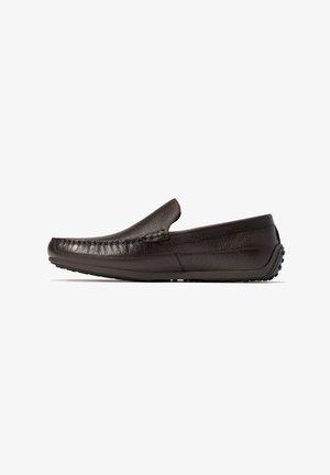 Zapato de cuero marrón oscuro sin cordones, con una parte superior texturizada, puntera redonda y suela de goma con pequeños puntos antideslizantes. Diseño sencillo y de perfil bajo.