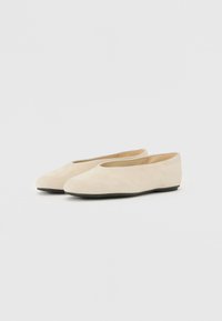Beige Wildleder Ballerinas mit runder Spitze, minimalistischem Design und schwarzer Gummisohle. Weicher Stoff, keine sichtbaren Beschläge oder Akzente.