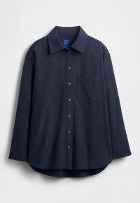 Camicia blu scuro con bottoni realizzata in tessuto strutturato. Presenta un colletto appuntito, maniche lunghe e una tasca sul petto. Orlo arrotondato.
