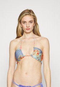 Top de biquíni floral com padrão de grelha azul, amarrações no pescoço e detalhes coloridos. O material parece suave com um design leve.