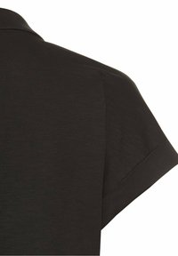 Musta lyhythihainen polo-paita, jossa on sileä pinta, klassinen kaulus ja rento istuvuus, keskittyen yksinkertaisiin muotoiluelementteihin.
