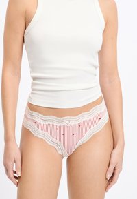 Rote und weiße gestreifte Damenunterwäsche mit Spitzenbesatz und kleinen roten Herzchen; weicher Stoff mit einem niedrig geschnittenen Design.