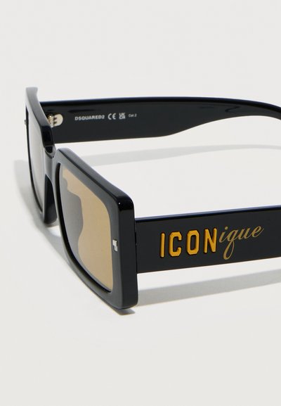 Μαύρα ορθογώνια γυαλιά ηλίου με καφέ φακούς, με την επιγραφή «ICONique» σε χρυσό στο πλάι και τη σήμανση «DSQUARED2» στο εσωτερικό του βραχίονα.