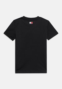 Μαύρο T-shirt με κοντά μανίκια και μικρό λογότυπο Tommy Hilfiger στο πίσω μέρος του λαιμού, απλωμένο επίπεδα σε λευκό φόντο.