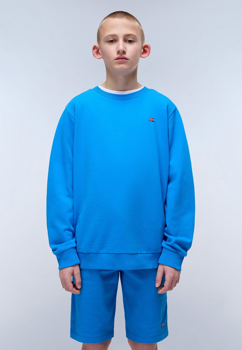 Completo felpa blu e pantaloni corti realizzato in tessuto morbido; presenta un collo rotondo, maniche lunghe e un piccolo dettaglio con logo sul petto.