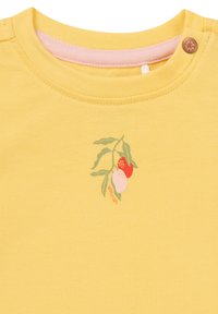 Gelbes Baumwoll-T-Shirt mit Rundhalsausschnitt, das ein kleines, farbenfrohes Obstmotiv mit grünen Blättern und braunen Knopfdetails zeigt.