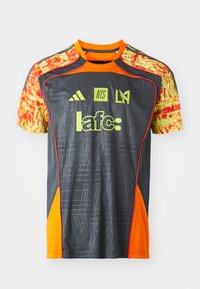 Grå sportshem med livlige orange accenter og mønstrede gule ærmer. Har logoer og tekst i lys grønt. Letvægtsstof.