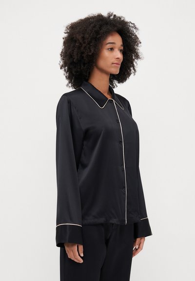 Black satin shirt with long sleeves, collar, and contrasting light-colored piping along the collar and button placket.