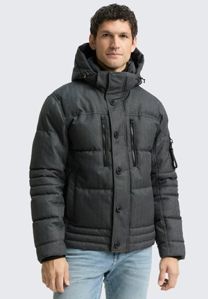 Veste matelassée gris foncé avec un col haut, des fermetures à boutons et à zip, deux poches poitrine, et une capuche réglable. Tissu texturé.