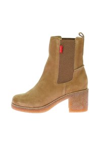 Botín de ante marrón con panel elástico lateral, punta redonda y tacón de bloque grueso de 5 cm. Cuenta con una suela de goma texturizada y una lengüeta trasera para tirar.