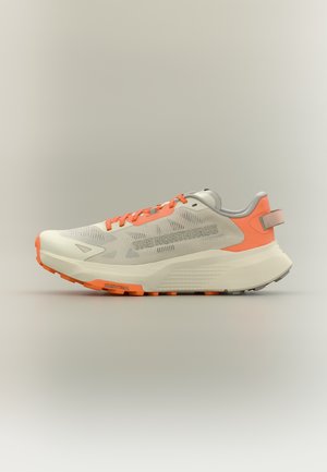 Chaussure de course beige clair et orange avec côtés en mesh, semelle épaisse, lacets orange et logo "THE NORTH FACE" sur le côté.