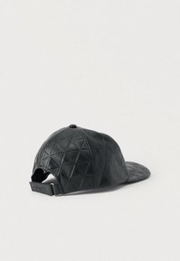 Μαύρο καπέλο από δερμάτινο υλικό με υφή και διακοσμημένο με σχέδιο ρόμβου, διαθέτει επίπεδη γείσο και ρυθμιζόμενο λουράκι στο πίσω μέρος.