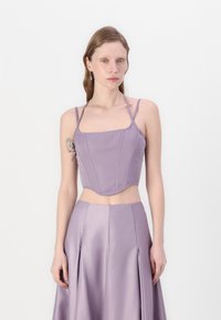 Lavendel cropped topp med tynne stropper, firkantet halslinje, strukturerte sømmer og en glatt satengfinish, parret med et matchende skjørt.