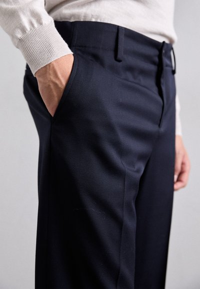 Pantaloni tailleur blu con una texture liscia, due tasche laterali e una vestibilità classica. Presentano una vita sagomata e dettagli di cucitura discreti.