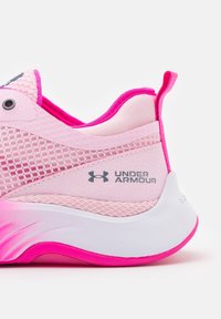 Vaaleanpunaiset urheilukengät, joissa on verkkokankaita ja synteettisiä materiaaleja. Varustettu valkoisella pohjalla, vaaleanpunaisilla yksityiskohdilla ja näkyvällä Under Armour -logolla sivussa.