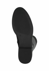 Suela de zapato negra con una superficie de goma texturada, diseño plano, tacón ligero y punta redondeada. Presenta bordes lisos y una construcción duradera.